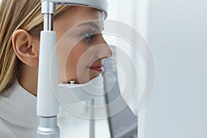 Eyesight Exam. Woman Checking Eye Vision On Optometry Equipment