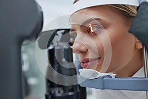 Eyesight Exam. Woman Checking Eye Vision On Optometry Equipment