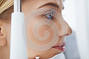 Eyesight Exam. Woman Checking Eye Vision On Optometry Equipment