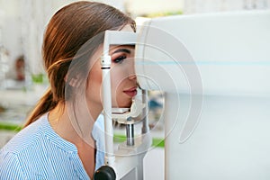 Eyesight Exam. Woman Checking Eye Vision On Optometry Equipment photo