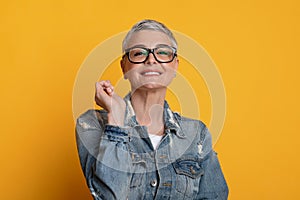 Eyewear Fashion. Happy Middle-Aged Woman Posing In Stylish Eyeglasses Over Yellow Background