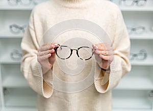 Eyewear modern glasses with stylish lens. Stylish eyeglasses holding in hands.