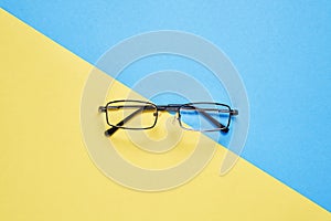 Eyewear placed on a pastel yellow and blue background divides the halves