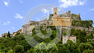 Eze village with it`s prominent ochre colored church and clocktower, France.