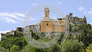 Eze village with it`s prominent ochre colored church and clocktower, France.
