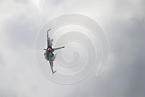 F-16 Jet with Afterburner On and Vapor Clouds Forming on Wings photo