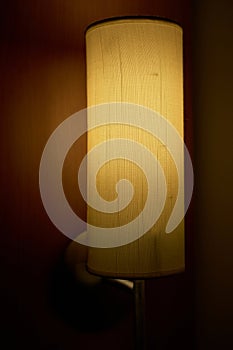 Fabric bedside lamp on wooden surround.