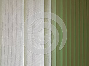 Fabric blinds in the form of green vertical stripes.