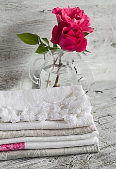 Fabric cotton kitchen towels and pink roses in a glass vase