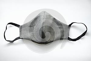 fabric grey mask with black elastic bands on a white background. top view