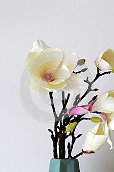 fabric magnolia in a decorative vase against a white background