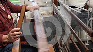 fabric making loom close-up. a woman makes fabric on a satre wooden loom