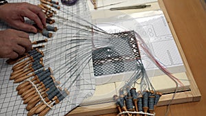 fabric making loom close-up. a woman makes weaving on bobbins