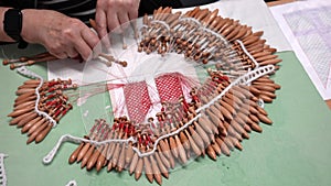 fabric making loom close-up. a woman makes weaving on bobbins