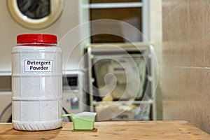 Fabric powder laundry detergent with scooper against washing machine background