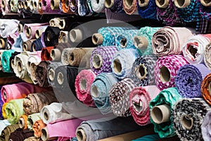 Fabric rolls at market stall , textile industry background