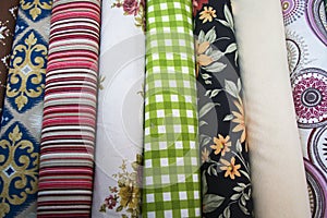 Fabricate silk and cloth on the shop shelf, rolled silk in the market, multicolor and many pattern texture background