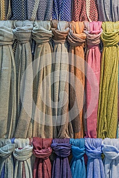Fabrics of different colors and textures hang vertically.