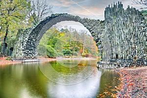 Fabulous autumn landscape in Azalea and Rhododendron Park Kromlau. Rakotz Bridge Rakotzbrucke, Devil`s Bridge