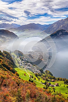 Fabulous autumn view of Stansstad city and Lucerne lake with mountaines and fog