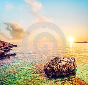 Fabulous beautiful magic dawn with alone stone among water on Bataria Beach on the coast of the Ionian Sea in Corfu