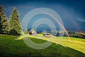 Fabulous evening scene of Compaccio village with huge rainbow on background, Seiser Alm or Alpe di Siusi location, Bolzano