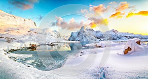 Fabulous frozen Flakstadpollen and Boosen fjords and reflection in water during sunrise with Hustinden mountain on background on photo