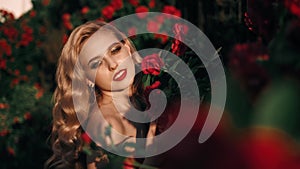Fabulous girl with red lips in red dress on awesome summer roses background. Fantasy woman portrait. Awesome blonde