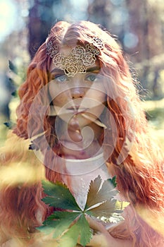 Fabulous portrait of a red-haired girl in nature with double exposure and glare. Beautiful redhead girl with long hair in forest