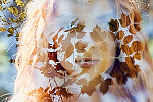 Fabulous portrait of a red-haired girl in nature with double exposure and glare. Beautiful redhead girl with long hair in forest