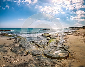 Fabulous seascape with rocky cliffs, sea bay, islets and faraglioni near by Frassanito Beach