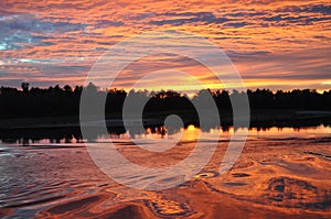 A fabulous sunset is reflected in the water of the Ukrainian river Desna