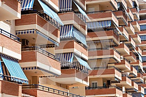 Facade of apartment building with balconies and awnings from the sun.