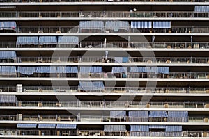 Facade of apartment building with terraces and striped awnings, concept of overcrowded space
