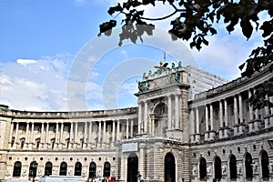 Facade, arranged in a semicircle, of a beautiful historic building, in the museum district in Vienna, with golden eagle and crown