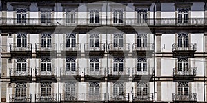 the facade and balcony balconies of the hotel with two men walking along