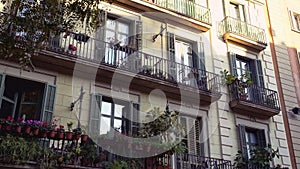 Facade of Barcelona old house with balconies with plants. Urban jungles. Ecological living