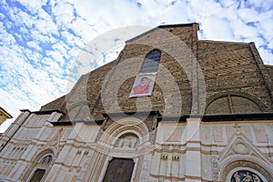 Facade of the basilica di San Petronio in the square, Piazza Maggiore across the blue sky in Bologna, Italy photo