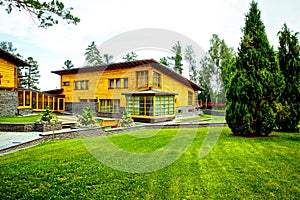 Facade of a beautiful wooden house with green garden