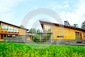 Facade of a beautiful wooden house with green garden