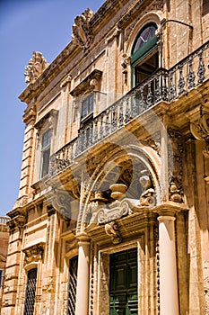 Facade of a building, door and balconies with worked structure in the center of Mdina (Malta