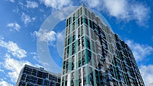 Facade of the building in green and lettuce colors, geometric patterns from windows and balconies, colored wall of a