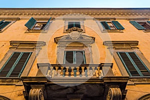 Facade of a building with Italian architecture and a balcony in Pisa, Italy