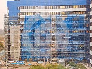 facade building under repair is covered blue protective construction net. Czech