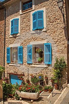 Facade of building with windows and blue shutters in ChÃÂ¢teaudouble.