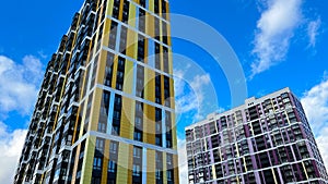 Facade of the building in yellow and orange colors, geometric patterns from windows and balconies, colored wall of a