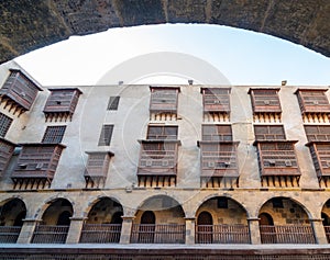 Facade of caravansary of Bazaraa framed by stone arch, with vaulted arcades and wooden oriel windows, Cairo, Egypt