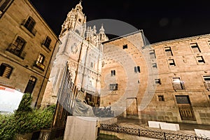 Facade of Casa de las Conchas in Salamanca at night, Spain, covered in scalloped shells, and Salamanca University at illuminated photo