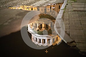 Facade of a church reflected in a puddle