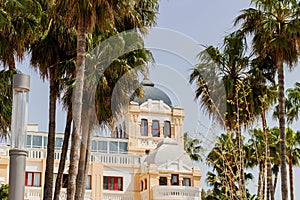 Facade of Ciutat Jardi hotel with a round roof surrounded by tall palm trees photo